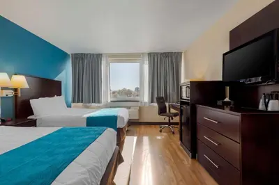 a hotel room with two beds and a flat screen tv at The Capitol Hotel in Hartford