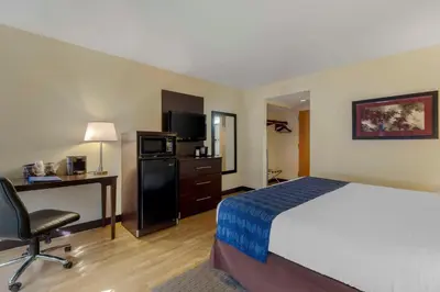 a hotel room with a bed and a desk and a chair at The Capitol Hotel in Hartford