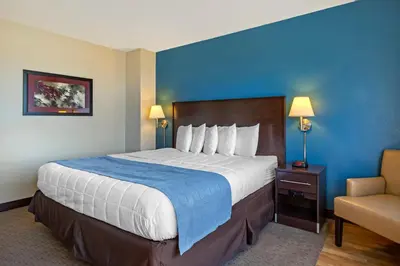 a hotel room with a large bed and a chair at The Capitol Hotel in Hartford