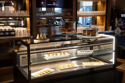 a display case in a bakery with various pastries at The Lloyd Stamford, Tapestry Collection by Hilton in Stamford
