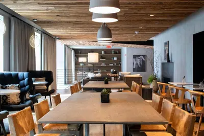 a restaurant with wooden ceilings and tables and chairs at The Lloyd Stamford, Tapestry Collection by Hilton in Stamford