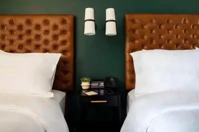 a bedroom with two beds with white pillows and a headboard at The Lloyd Stamford, Tapestry Collection by Hilton in Stamford