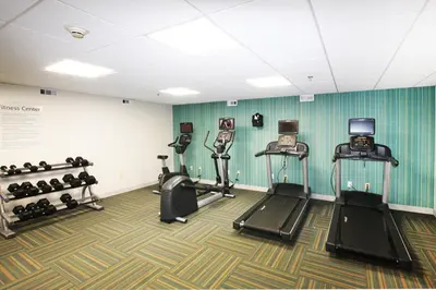 a gym with three treadmills and cardio machines at Holiday Inn Express Branford-New Haven by IHG in Branford
