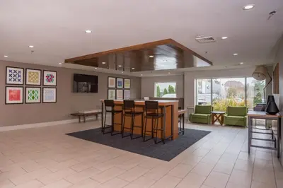 a lobby with a bar with chairs and a table at Holiday Inn Express Branford-New Haven by IHG in Branford