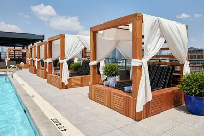 a row of umbrellas on a rooftop with a pool at Arlo Williamsburg in Brooklyn