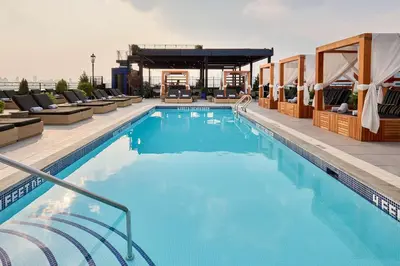 a large swimming pool with lounge chairs and a building at Arlo Williamsburg in Brooklyn