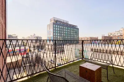 a balcony with two chairs and a view of a city at Arlo Williamsburg in Brooklyn