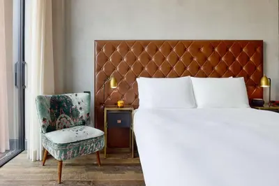 a bedroom with a large bed and a chair at Arlo Williamsburg in Brooklyn