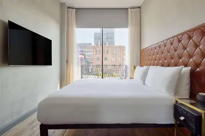 a bedroom with a large white bed and a window at Arlo Williamsburg in Brooklyn