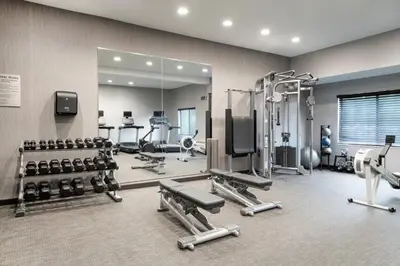a gym with a mirror and lots of equipment at Courtyard by Marriott Danbury in Danbury