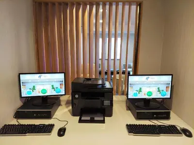 two computer monitors and a printer on a desk at Holiday Inn Express Maspeth by IHG in Queens