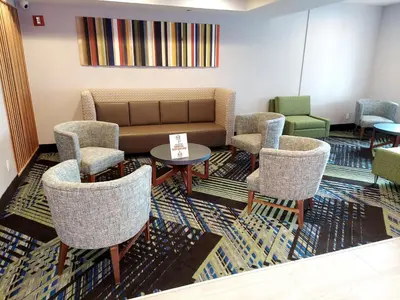 a waiting room with a couch and chairs at Holiday Inn Express Maspeth by IHG in Queens