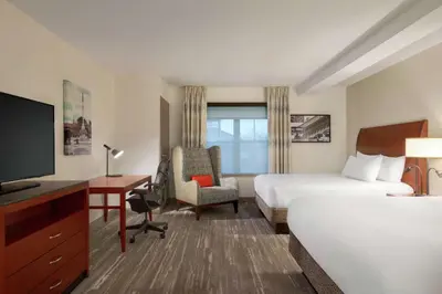 a hotel room with a bed and a desk and a television at Hilton Garden Inn Troy in Troy