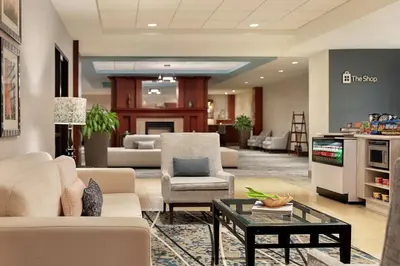 a living room with a couch and chairs and a table at Hilton Garden Inn Troy in Troy