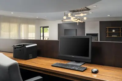 a computer monitor and a printer on a desk at Courtyard by Marriott Kingston in Kingston