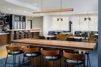 a restaurant with a bar with chairs and tables at Courtyard by Marriott Kingston in Kingston