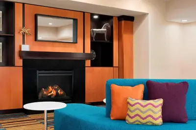 a living room with a blue couch and a fireplace at Fairfield Inn & Suites Hartford Manchester in Manchester