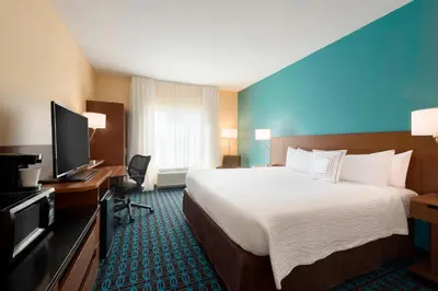 a hotel room with a large bed and a television at Fairfield Inn & Suites Hartford Manchester in Manchester