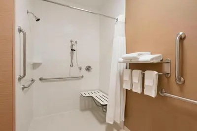 a bathroom with a shower with white towels at Fairfield Inn & Suites Hartford Manchester in Manchester