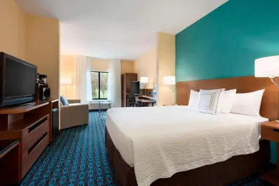 a hotel room with a large bed and a flat screen tv at Fairfield Inn & Suites Hartford Manchester in Manchester