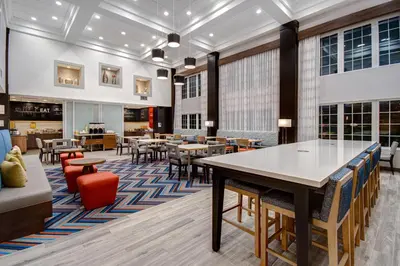 a dining room with tables and chairs and a cafeteria at Hampton Inn & Suites Yonkers in Yonkers