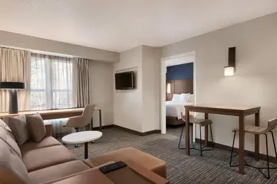 a hotel room with a couch and a table and a bed at Residence Inn by Marriott West Springfield in West Springfield