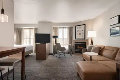 a hotel room with a couch and a bed and a fireplace at Residence Inn by Marriott West Springfield in West Springfield