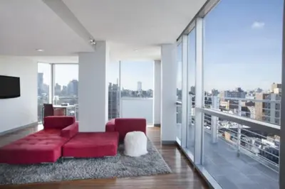 a living room with a red couch and large windows at Hotel on Rivington in New York