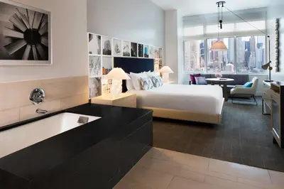 a hotel room with a bed and a living room at Ink 48 Hotel in New York