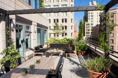 a rooftop patio with tables and chairs and plants at Smyth Tribeca in New York