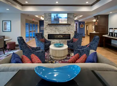 a living room with a couch and chairs and a fireplace at Hampton Inn by Hilton New Paltz, NY in New Paltz