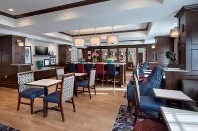 a restaurant with tables and chairs and a bar at Hampton Inn by Hilton New Paltz, NY in New Paltz