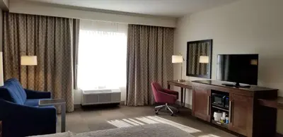 a hotel room with a television and two chairs at Hampton Inn by Hilton New Paltz, NY in New Paltz