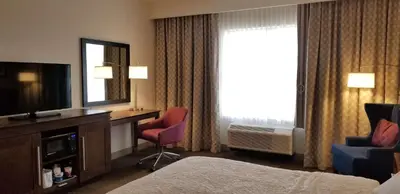 a hotel room with a bed and a tv and a window at Hampton Inn by Hilton New Paltz, NY in New Paltz