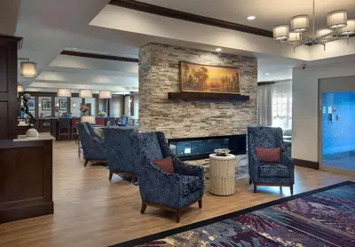 a lobby with chairs and a stone fireplace at Hampton Inn by Hilton New Paltz, NY in New Paltz
