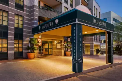 a sign for a hotel in front of a building at Inn at Great Neck in Great Neck