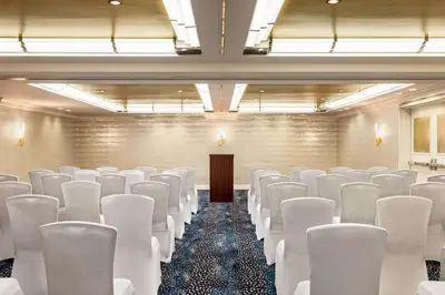 a conference room with white chairs and a podium at Inn at Great Neck in Great Neck