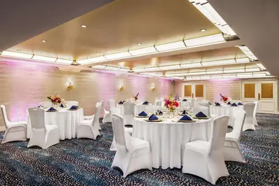 a conference room with white tables and white chairs at Inn at Great Neck in Great Neck