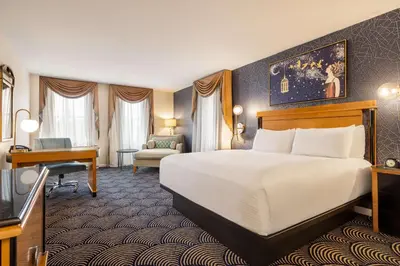 a hotel room with a bed and a desk at Inn at Great Neck in Great Neck