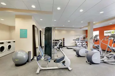 a gym with treadmills and ellipticals in a room at Home2 Suites by Hilton Middletown in Middletown