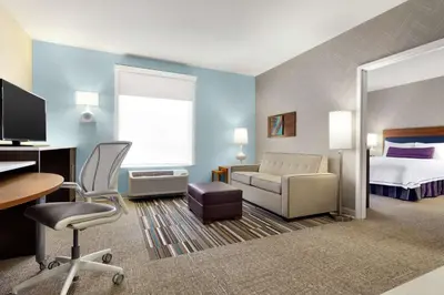 a hotel room with a bed and a desk and chair at Home2 Suites by Hilton Middletown in Middletown