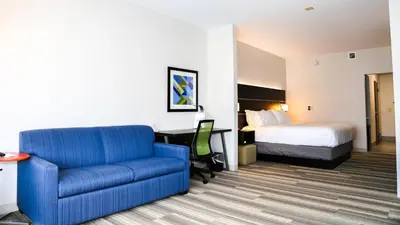 a hotel room with a couch and a bed at Holiday Inn Express & Suites Kingston-Ulster by IHG in Lake Katrine