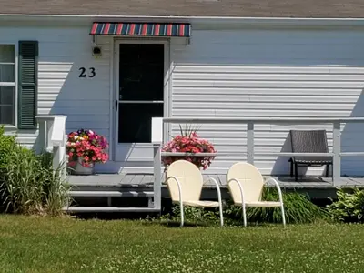 two chairs and a table on the front porch of a house at Lake View Motel in Cooperstown