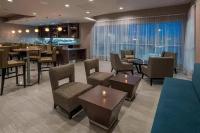 a hotel lobby with tables and chairs and a bar at Residence Inn by Marriott Fishkill in Fishkill