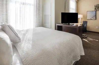 a bedroom with a white bed and a television at Residence Inn by Marriott Fishkill in Fishkill