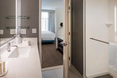 a bathroom with a sink and a bed in a room at Residence Inn by Marriott Fishkill in Fishkill