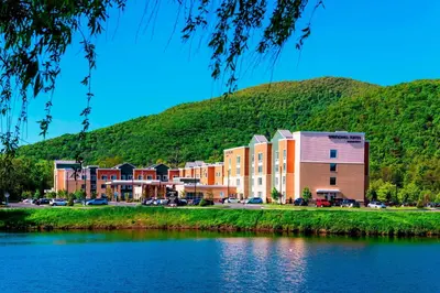a building next to a body of water with a mountain at SpringHill Suites by Marriott Fishkill in Fishkill