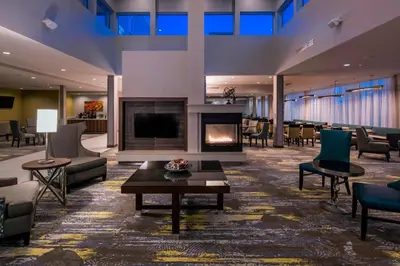 a lobby with a fireplace and chairs and a table at SpringHill Suites by Marriott Fishkill in Fishkill