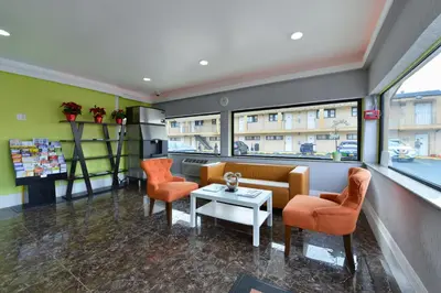 a waiting room with orange chairs and a table at Inn At Jericho in Jericho