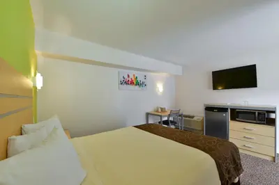 a hotel room with a bed and a flat screen tv at Inn At Jericho in Jericho